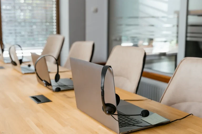 Laptops and headsets on a meeting room table