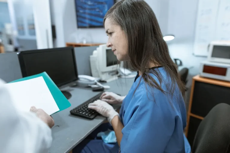 Healthcare worker typing at a computer