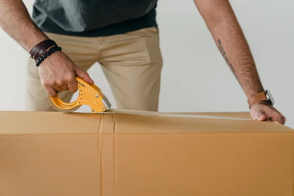 A cardboard box being sealed with tape