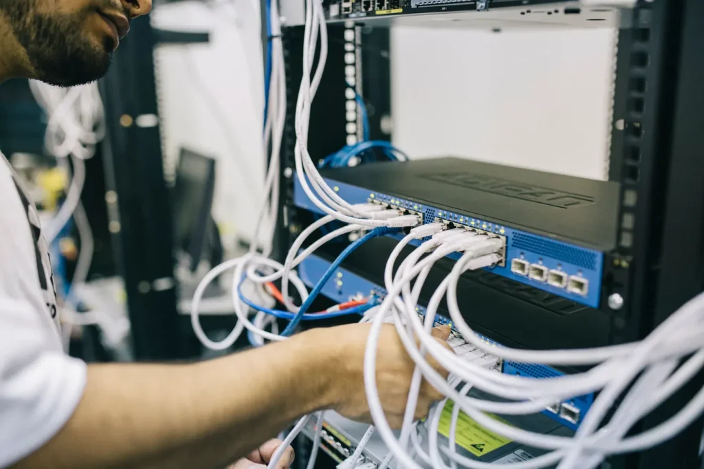 Engineer patching network cables into a switch