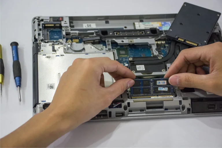 Hands fitting memory into an open laptop